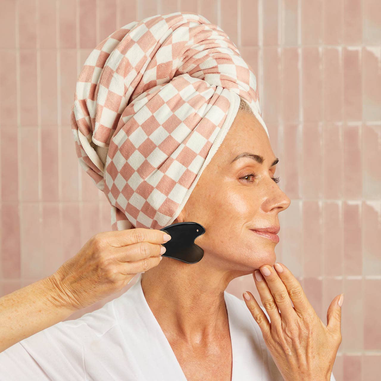 KITSCH stainless steel Gua Sha tool in matte black with smooth, curved edges for facial massage and skincare benefits