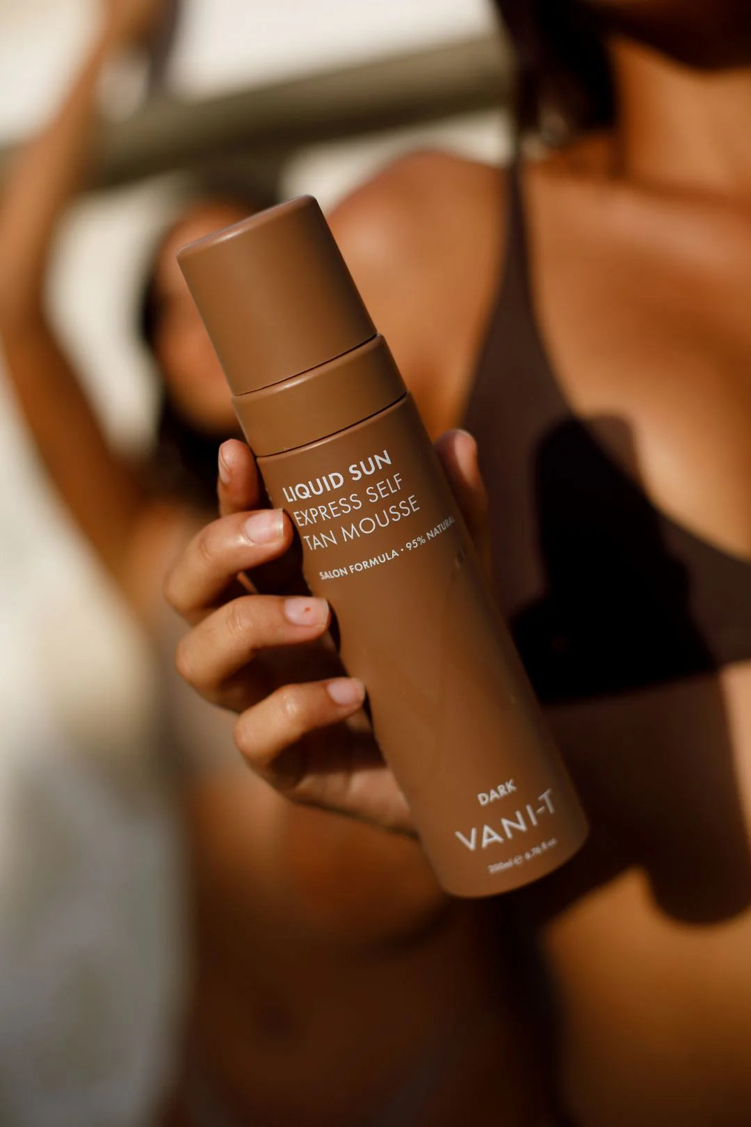 VANI-T Liquid Sun Express Self Tan Mousse in dark shade, showing the foam texture in a clear bottle with a pump applicator.