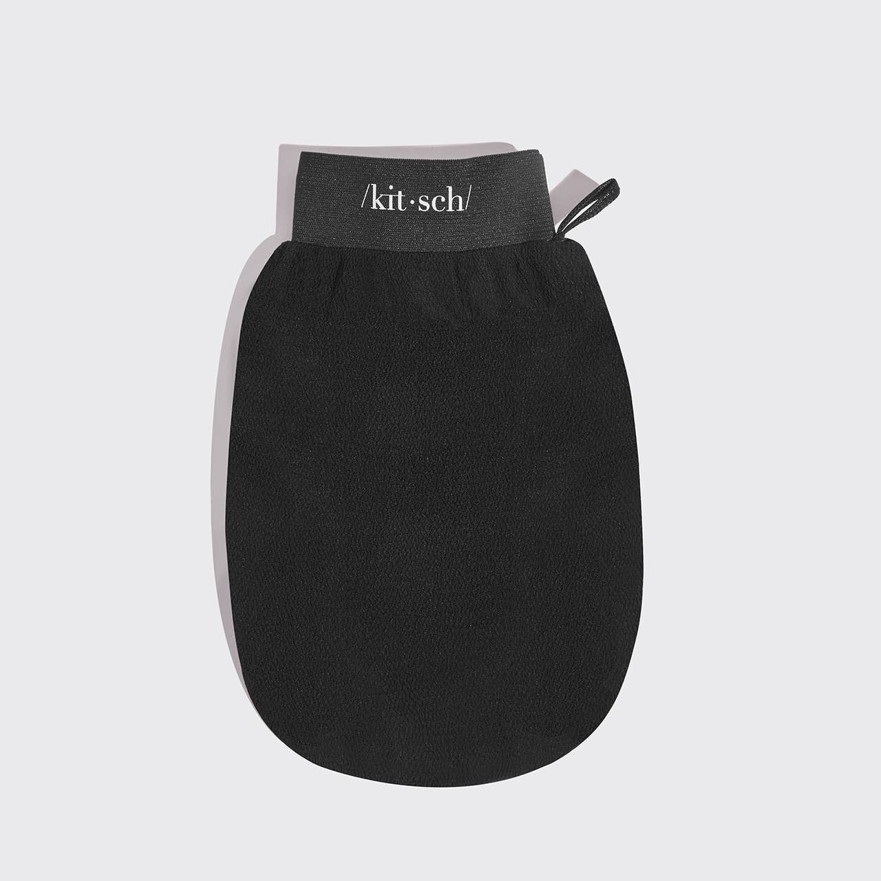 Black exfoliating glove by KITSCH for gentle skin exfoliation and cleansing in skincare routines.
