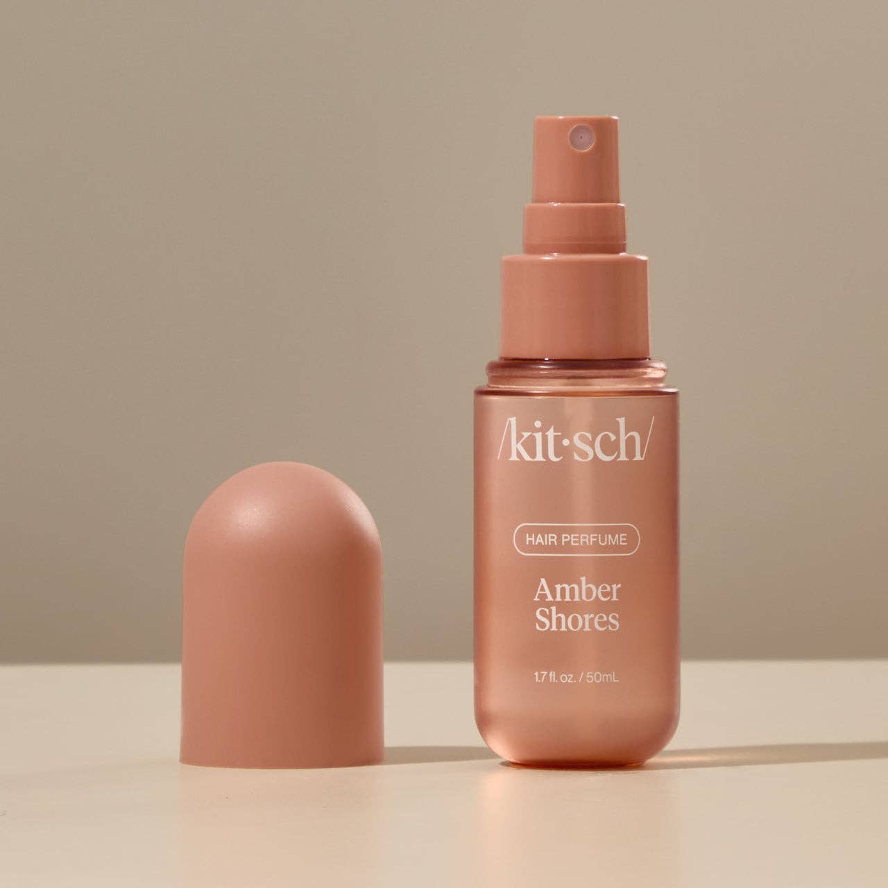 KITSCH Amber Shores Hair Perfume bottle with a clear glass design and amber-colored liquid inside, set against a neutral background.