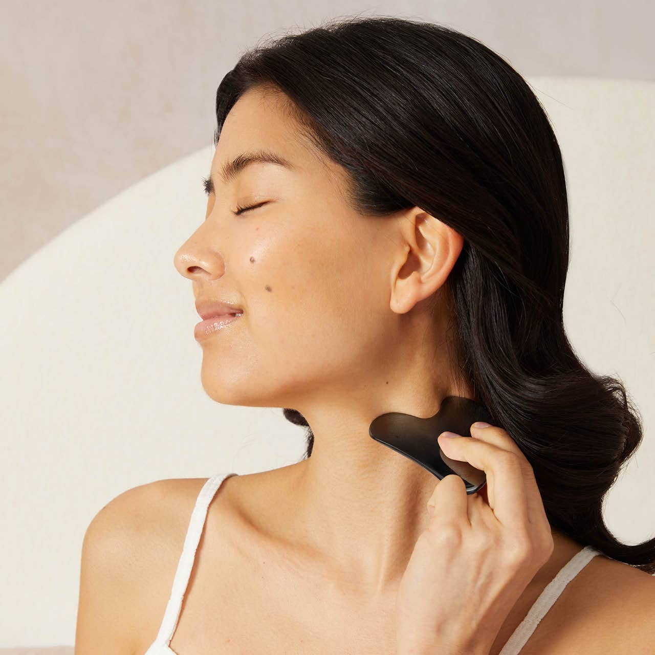 KITSCH stainless steel Gua Sha in matte black, facial massage tool with smooth edges for skincare and facial contouring.