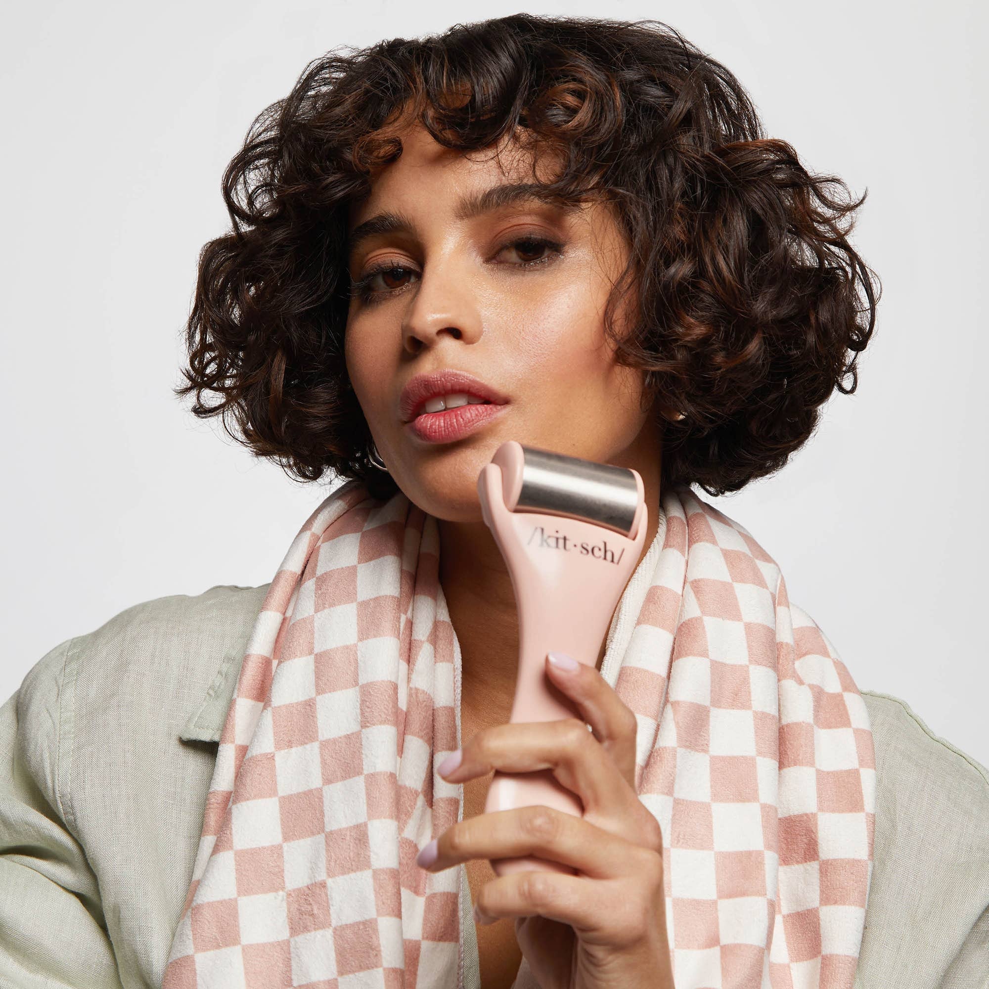 KITSCH Ice Roller in terracotta color, cylindrical skincare tool with handle and rolling head for facial cooling and soothing.